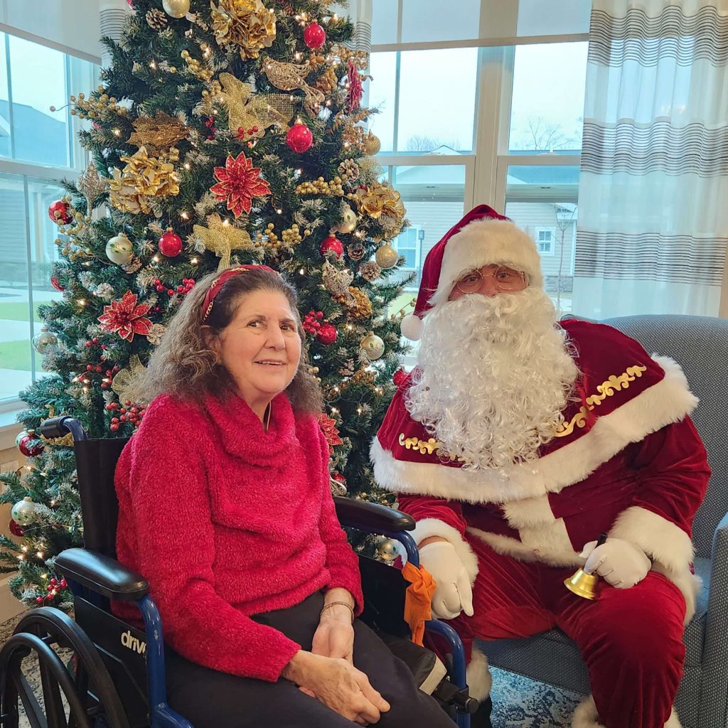 Resident with Santa Claus in front of a Christmas tree