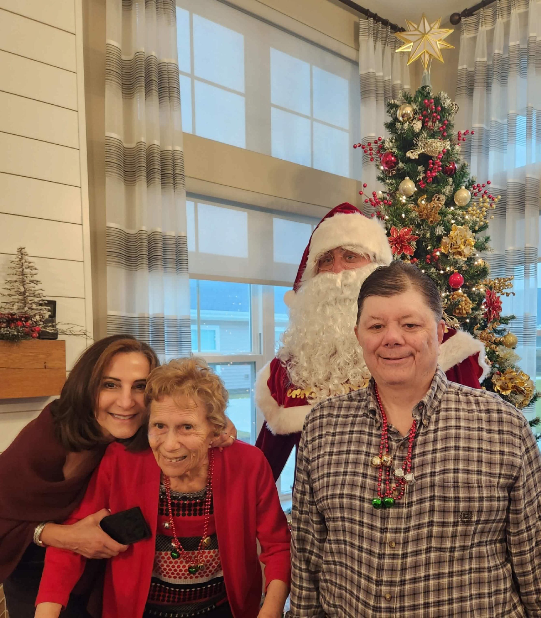 Residents and staff celebrate with Santa in festive attire.
