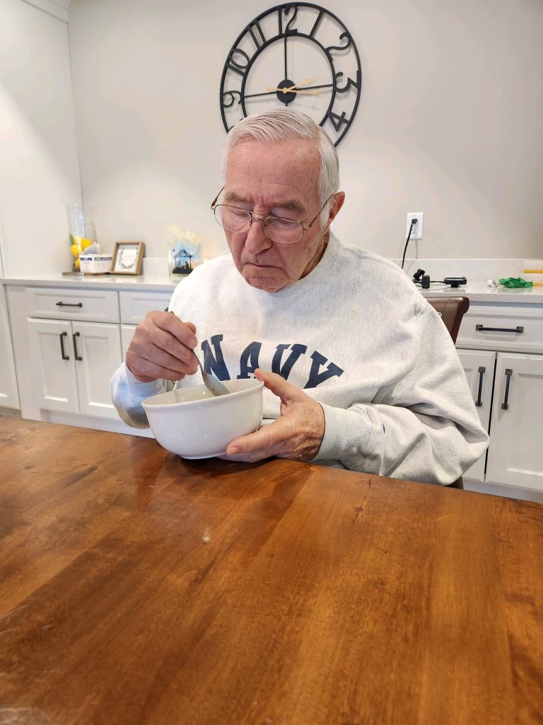 Senior man enjoying a meal at a table.