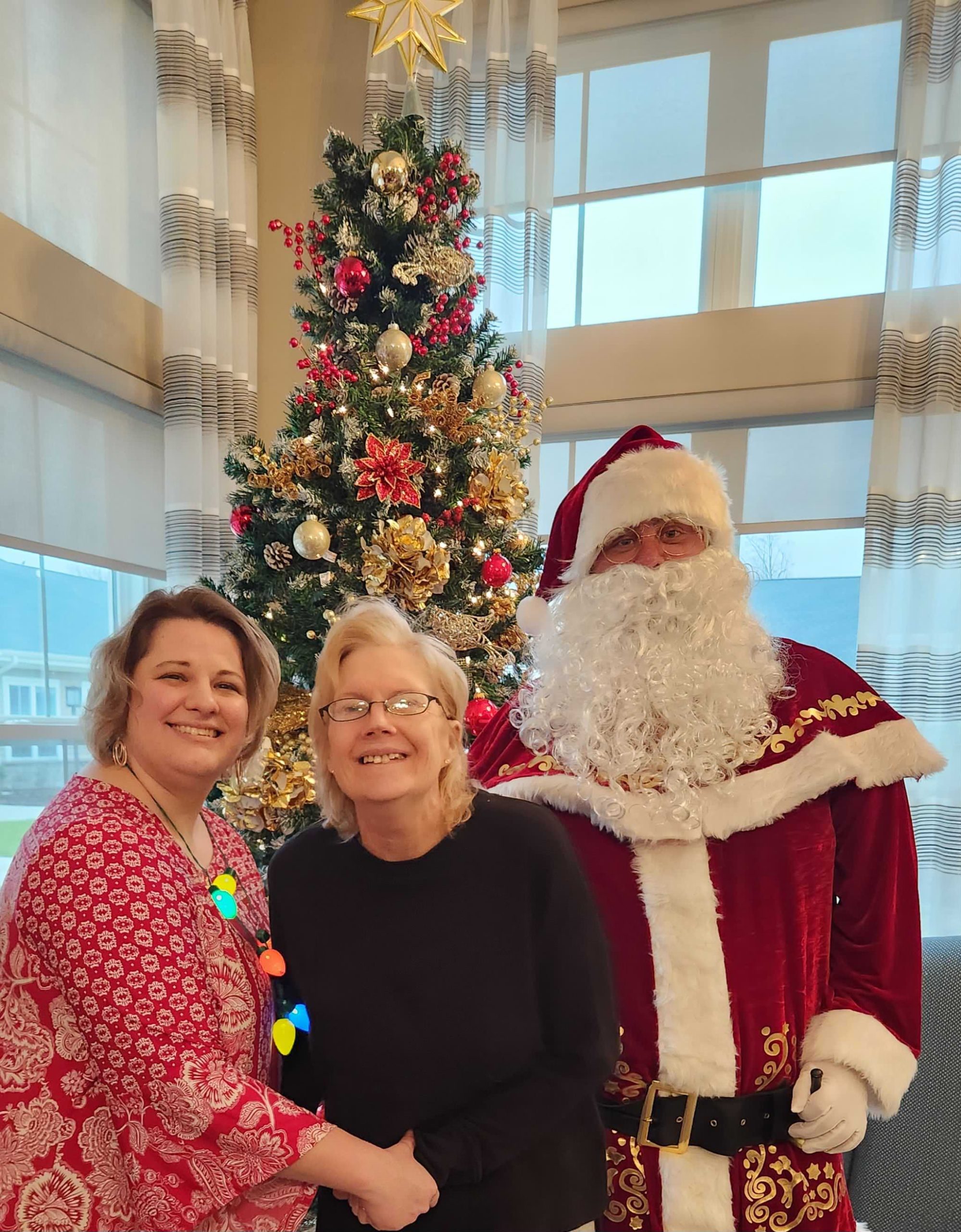 Residents with Santa by a Christmas tree