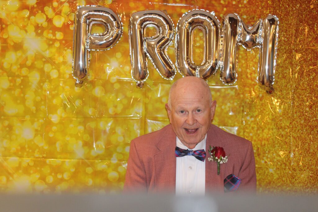 Elderly man enjoying a prom-themed event