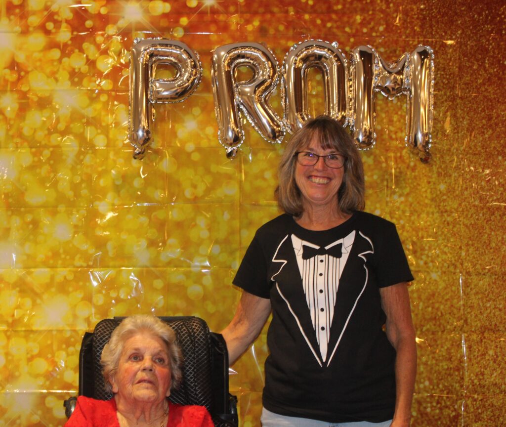 Resident and staff member posing at prom event.