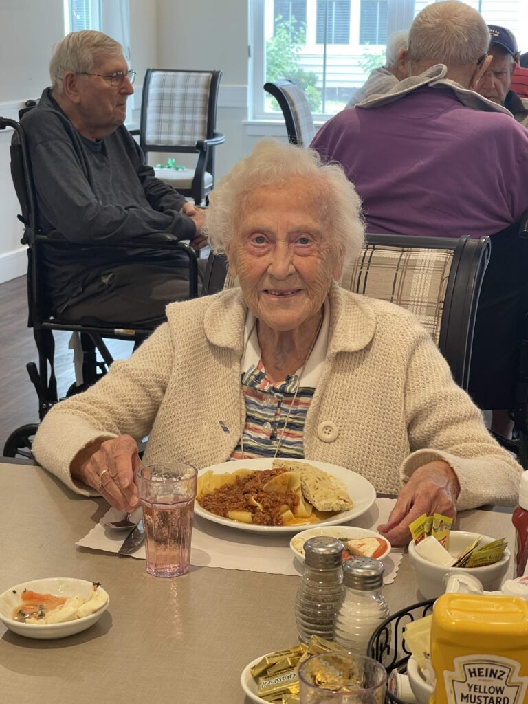 Elderly woman enjoying lunch in dining area