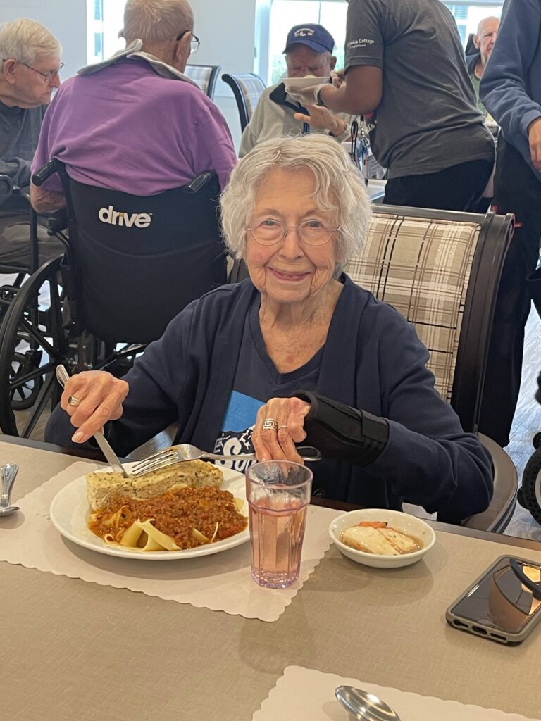 Senior resident enjoying a meal in the dining room.
