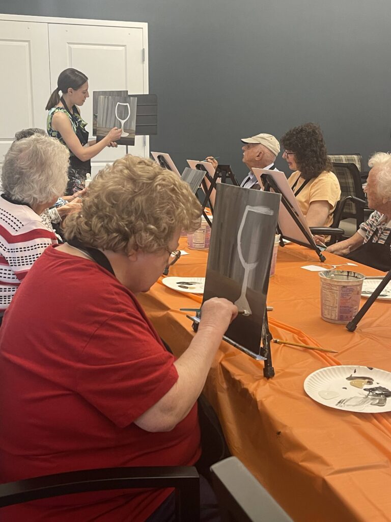 Seniors participating in a painting activity indoors.