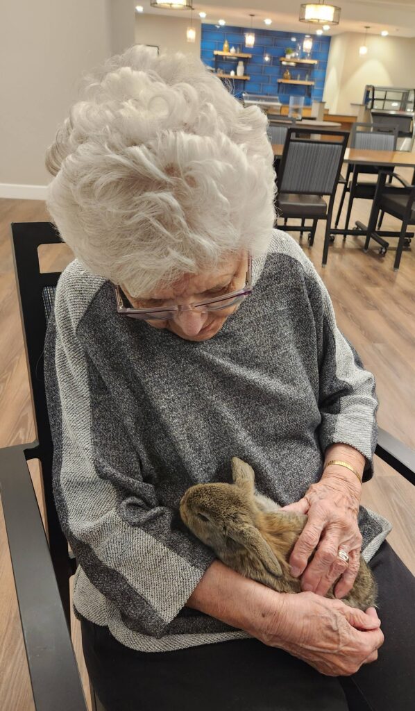 Resident holding a bunny in a lounge area