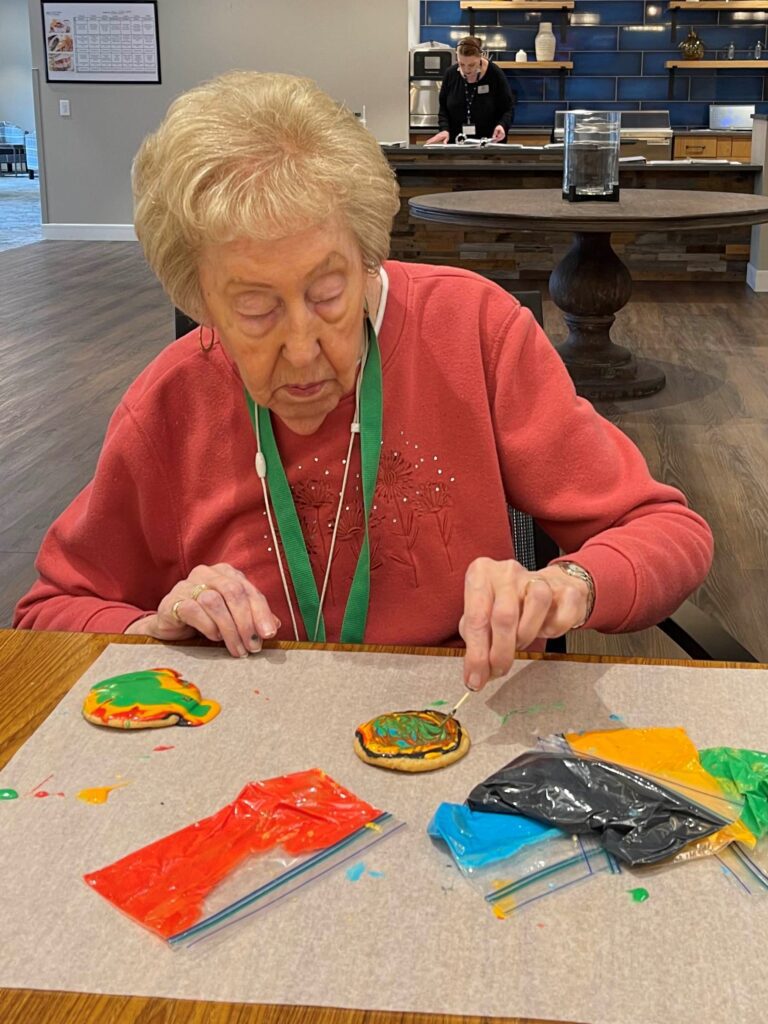 Resident decorating cookies during an activity.