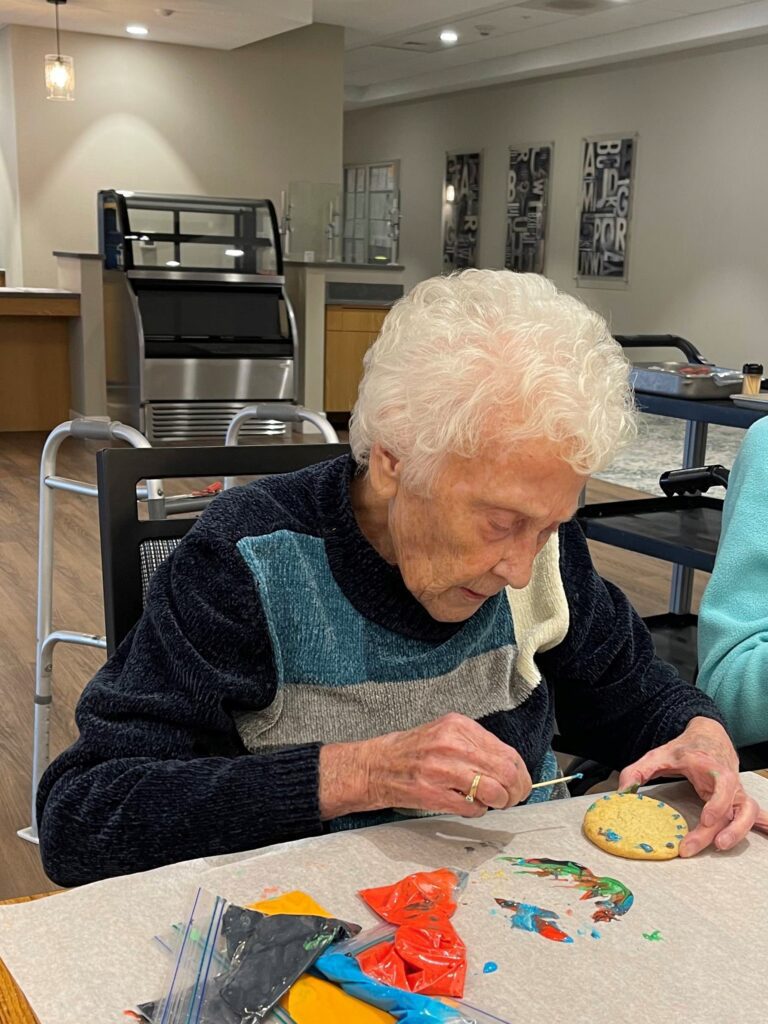 Resident painting a cookie during an activity session.