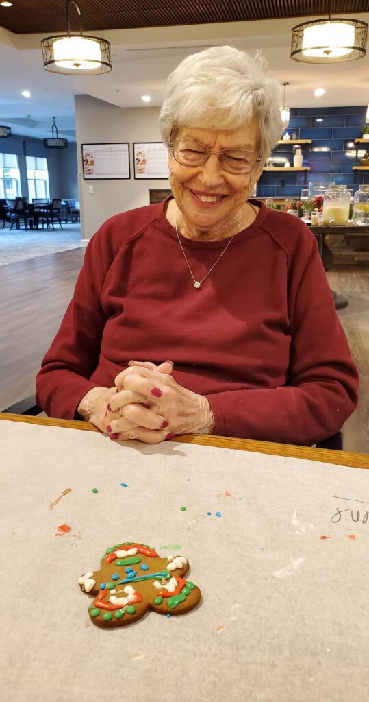 Senior resident enjoying cookie decorating activity.
