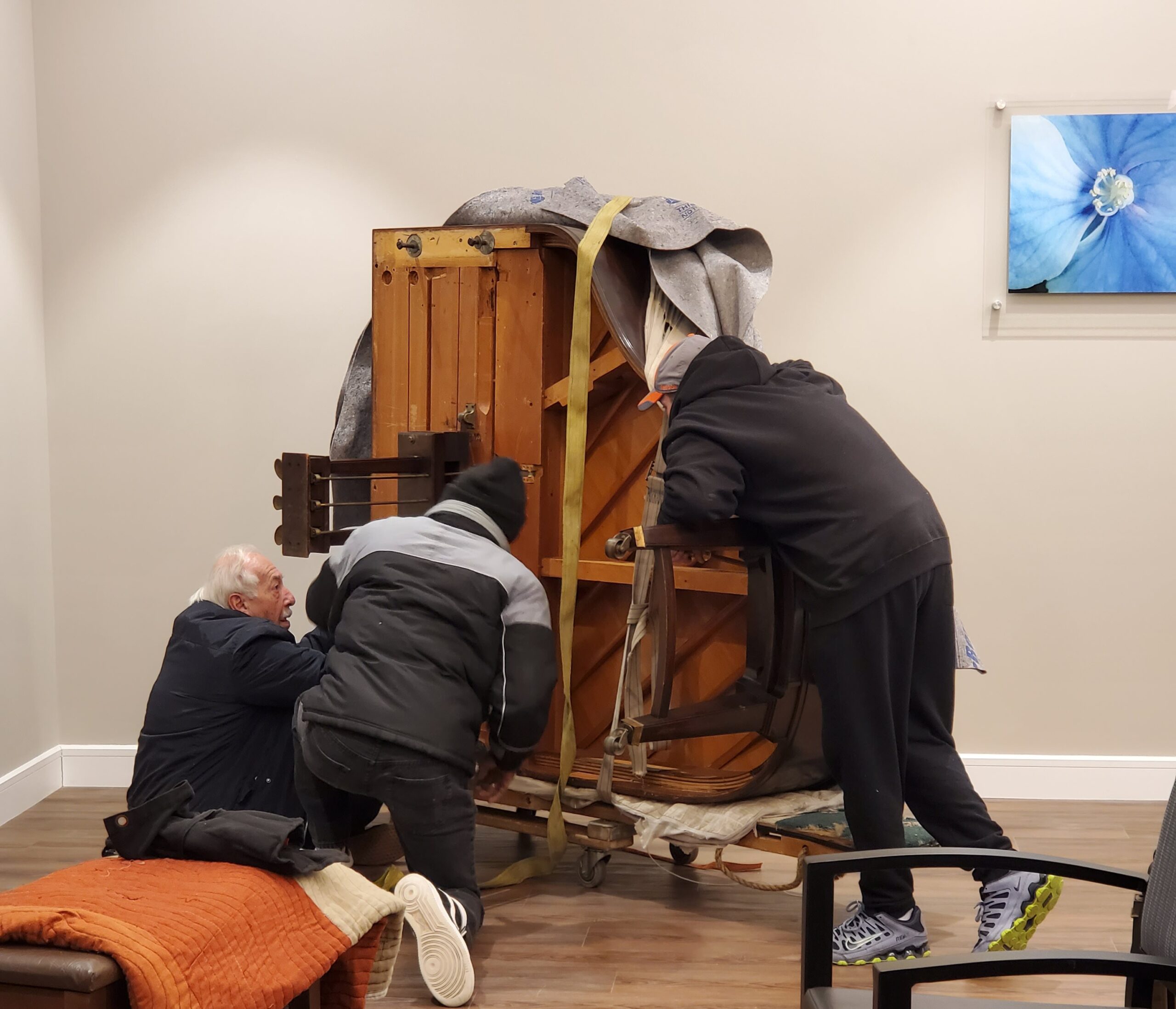 Two men adjusting furniture in a common area