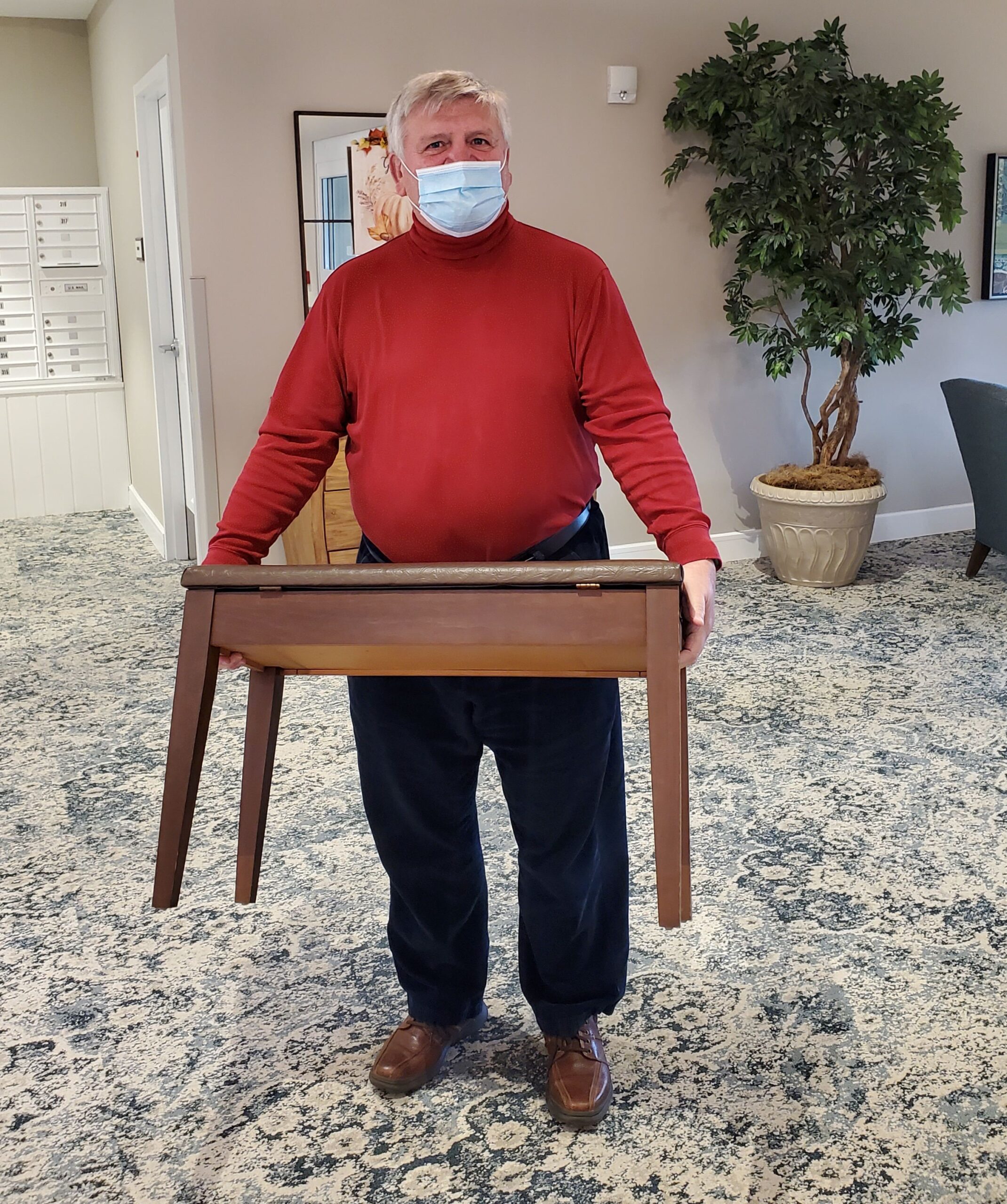 Staff member holding furniture in a common area.
