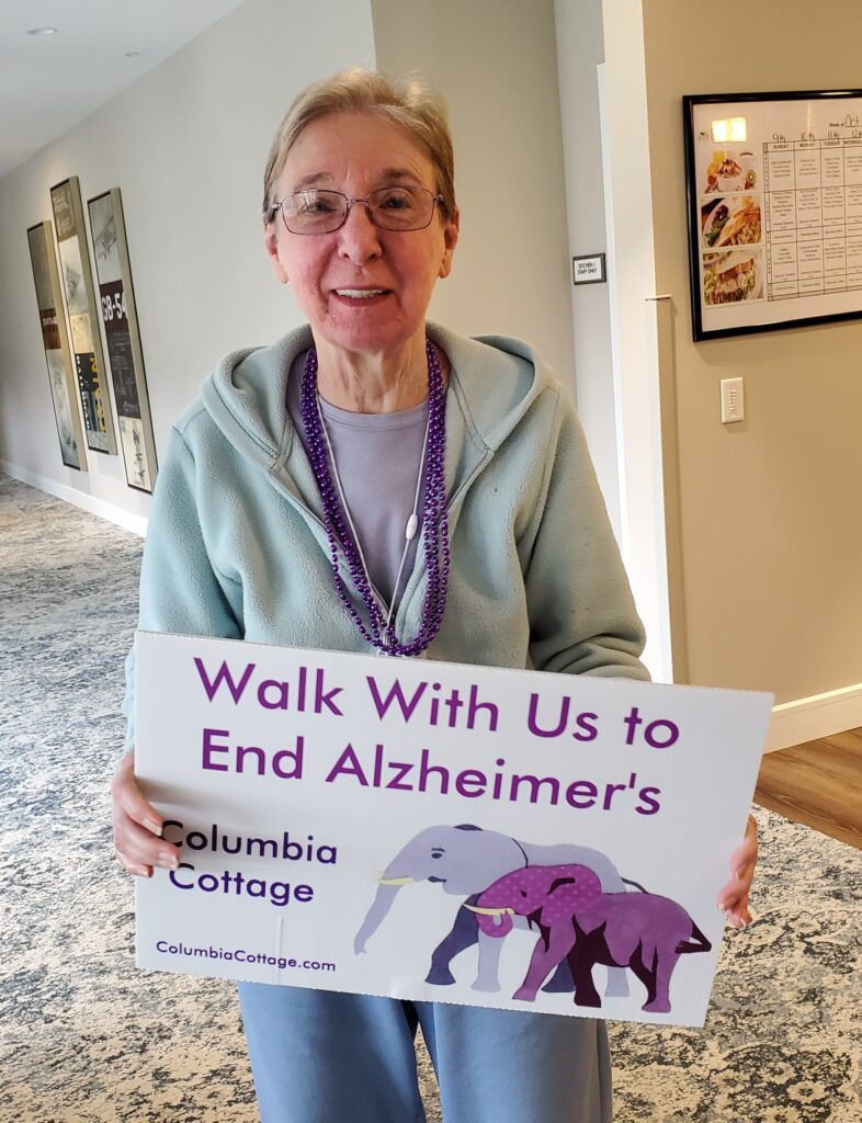 Resident holding a sign for Alzheimer's awareness.