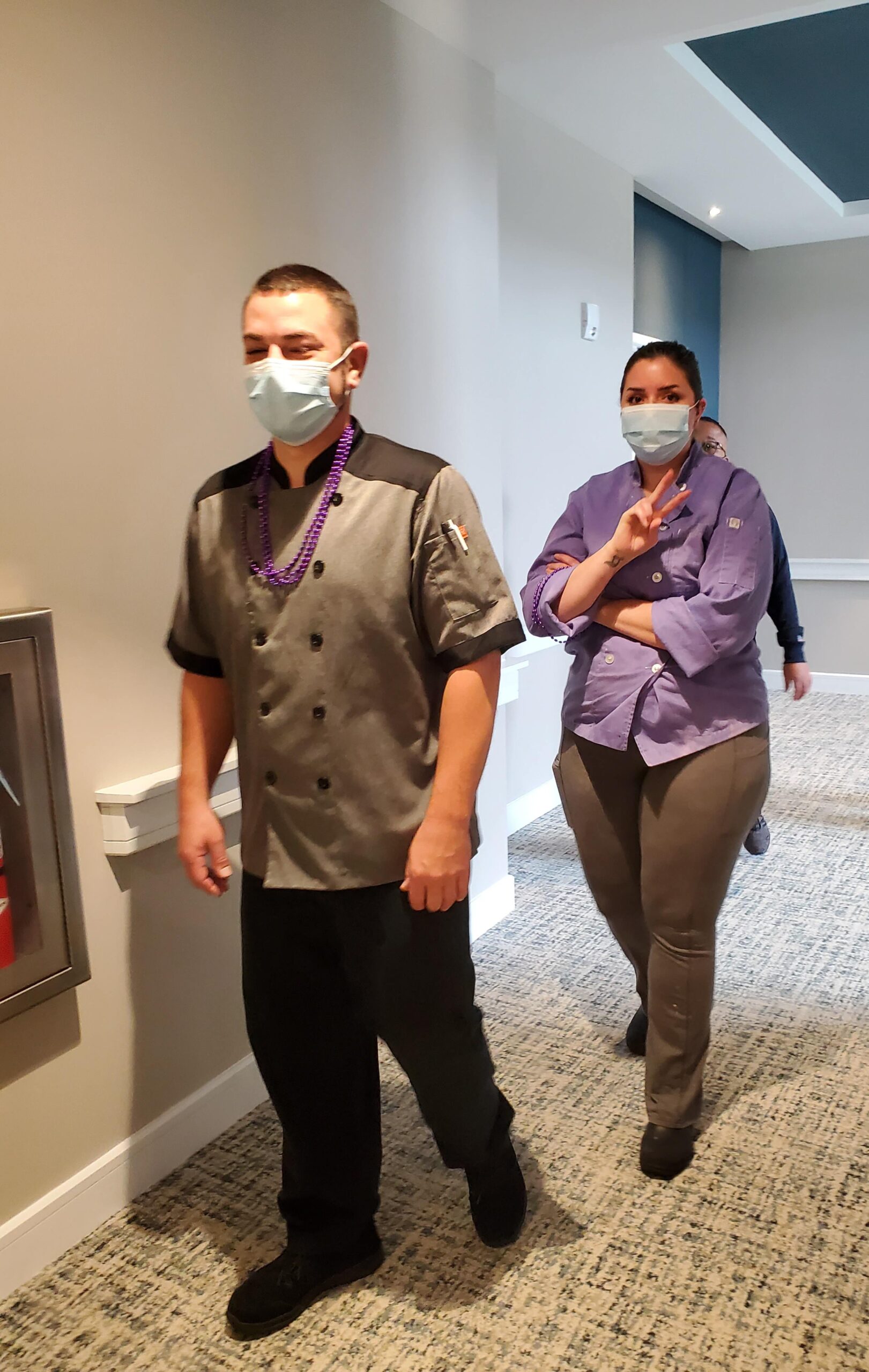 Staff members walking through the facility hallway.