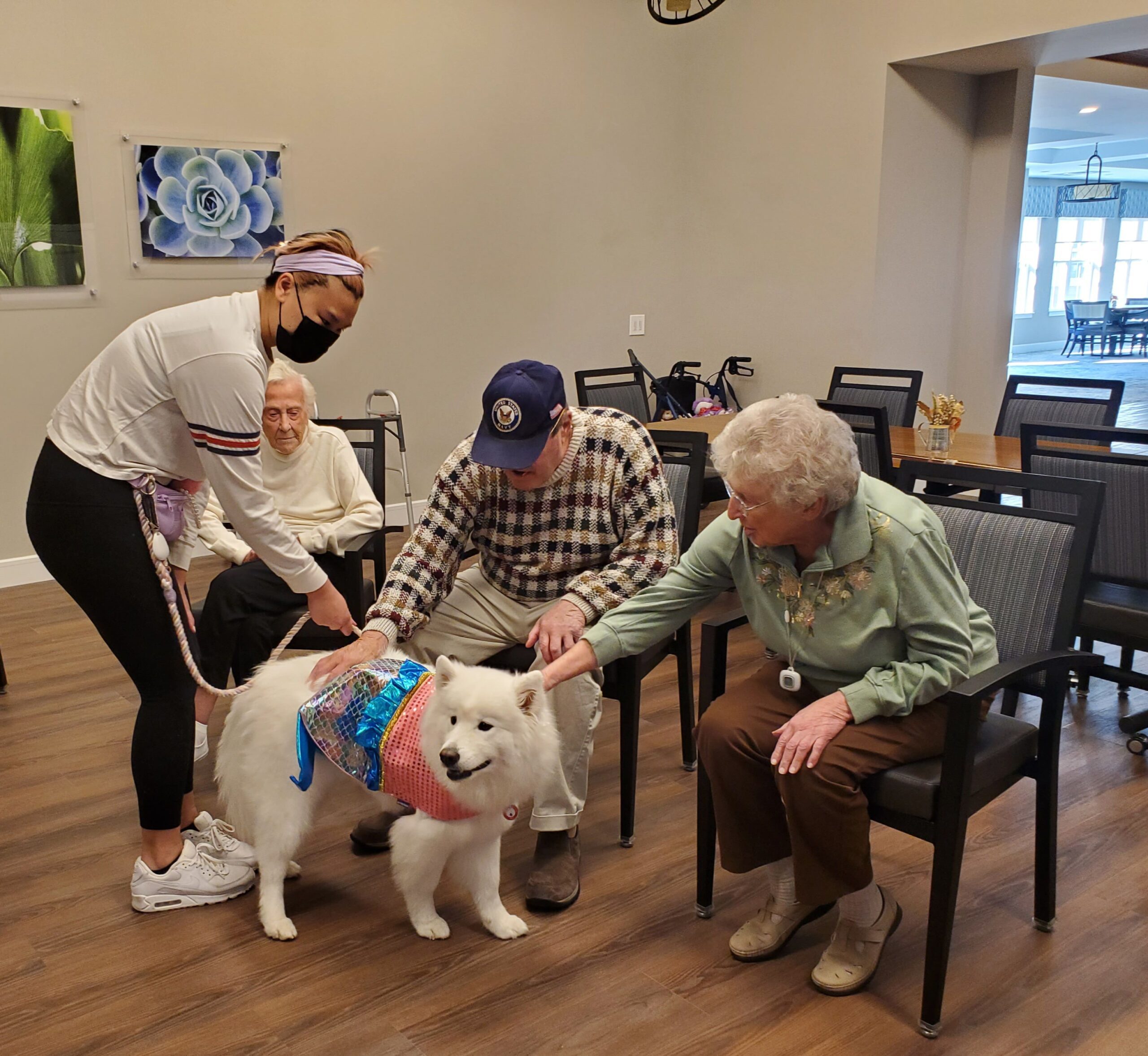 Residents interacting with a therapy dog and staff member.