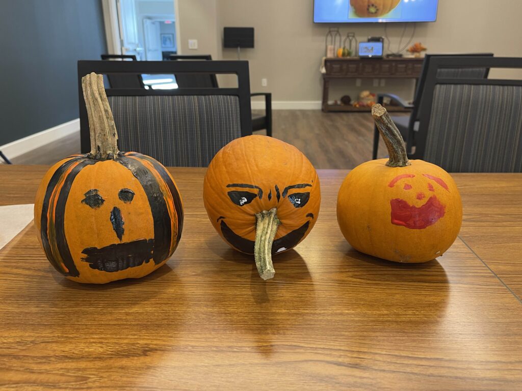 Three decorated pumpkins on a table