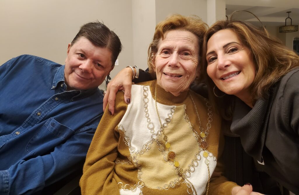 Three people smiling in a cozy indoor setting.