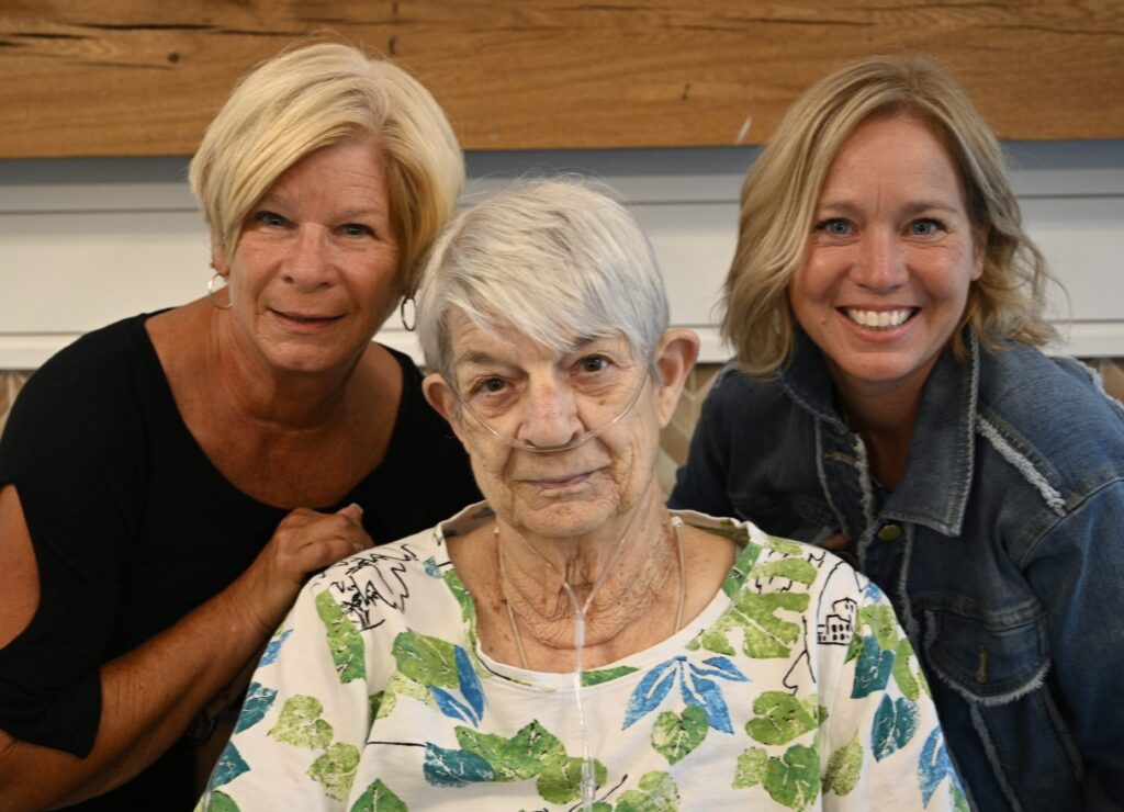 Two staff members with a resident in a communal space.
