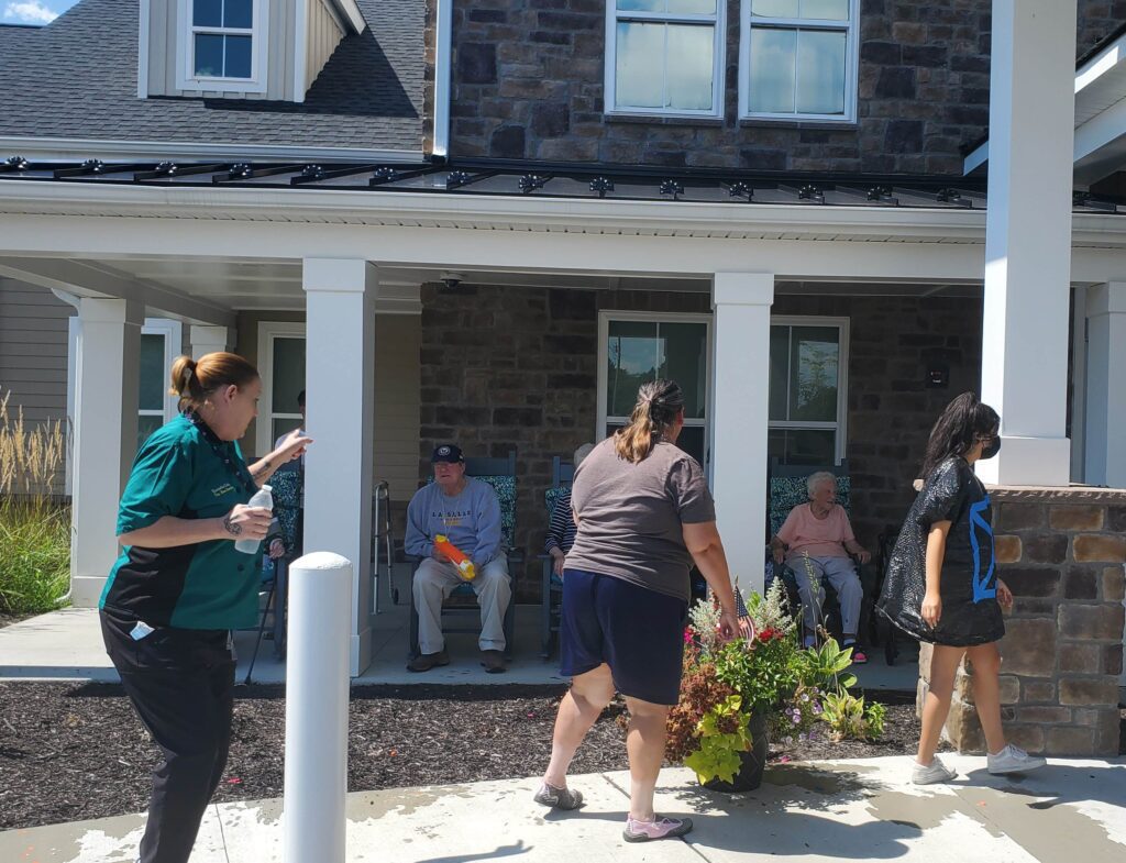 Residents enjoying time outdoors with staff assistance.