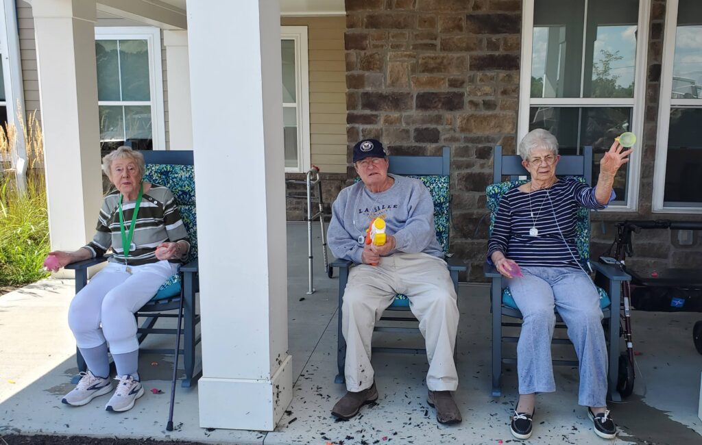 Three residents enjoying sitting on their porch.