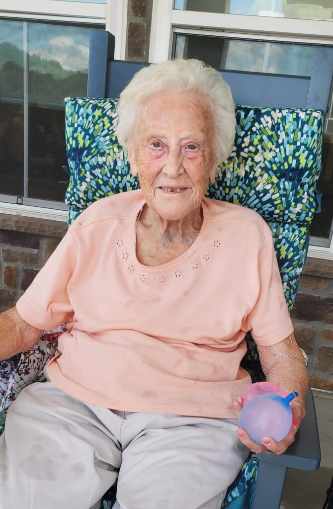 Resident enjoying time outdoors with a water balloon