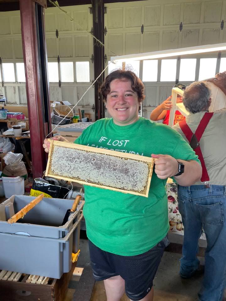 Person holding honeycomb in a facility activity.