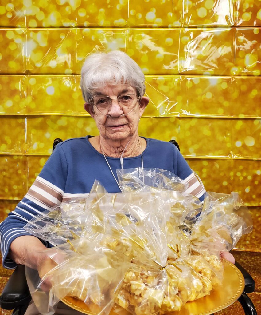 Senior woman holding a tray of packaged food.