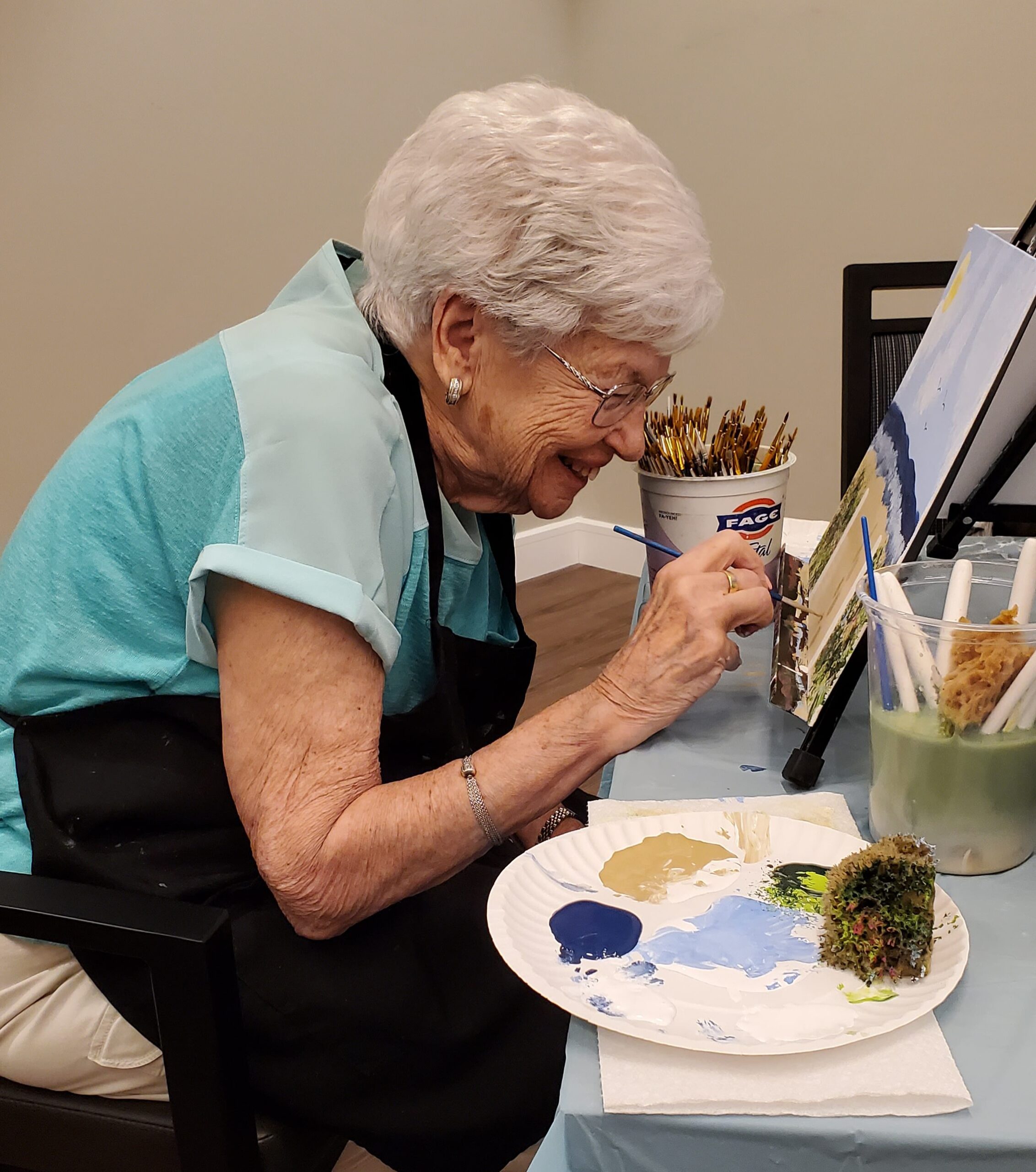 Senior woman painting at a table