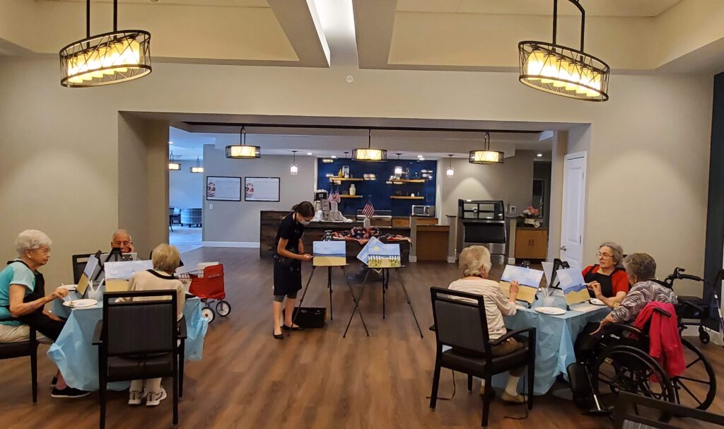 Residents engaged in a painting activity in the common area.