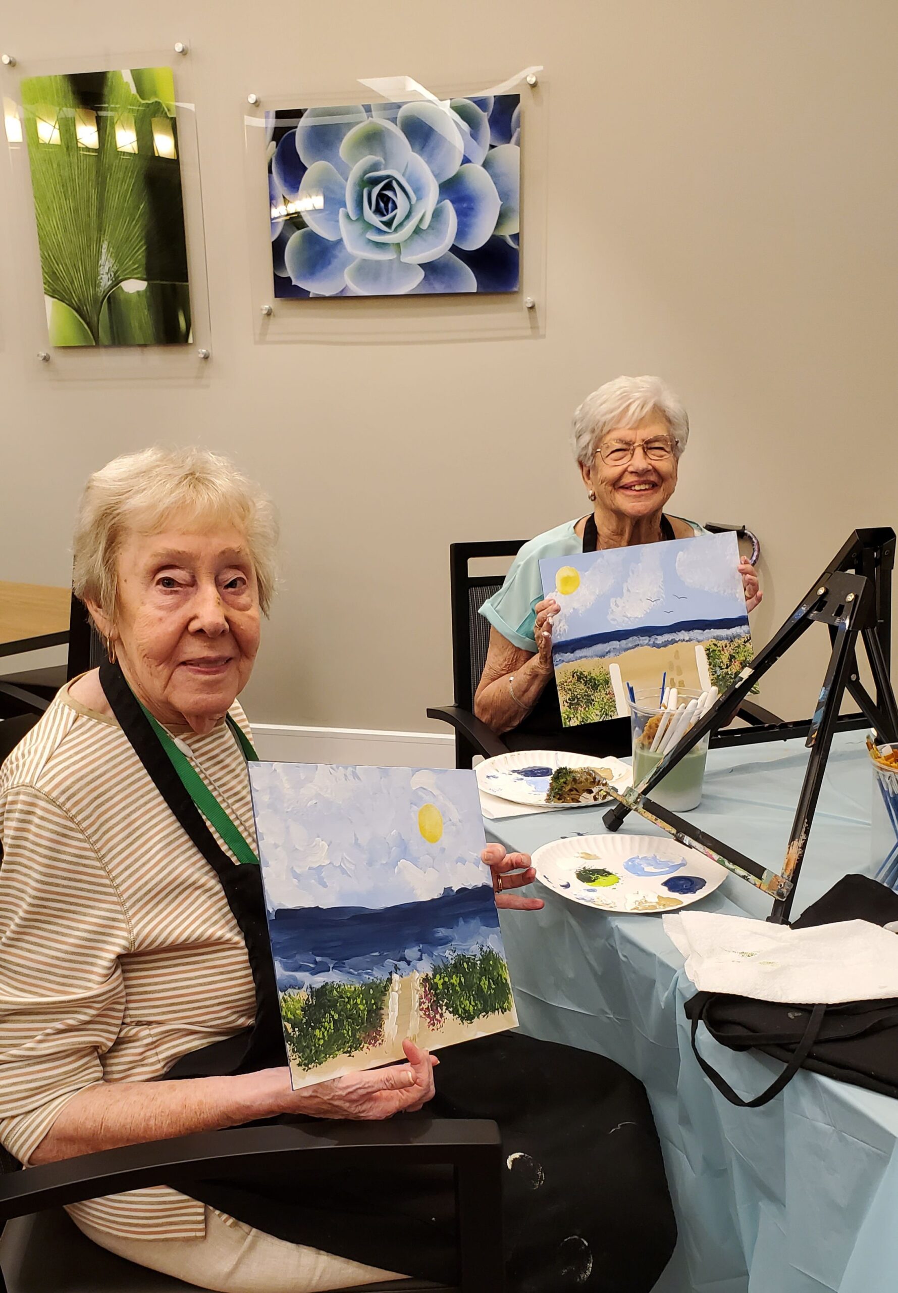 Two residents painting together in a common area.