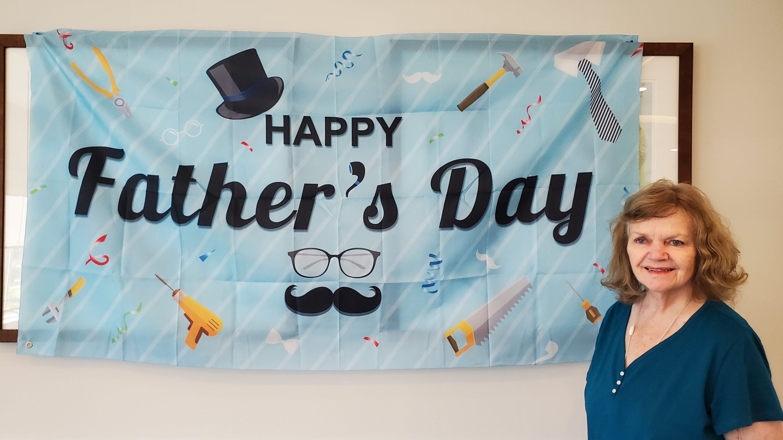 Resident celebrating Father's Day with banner.