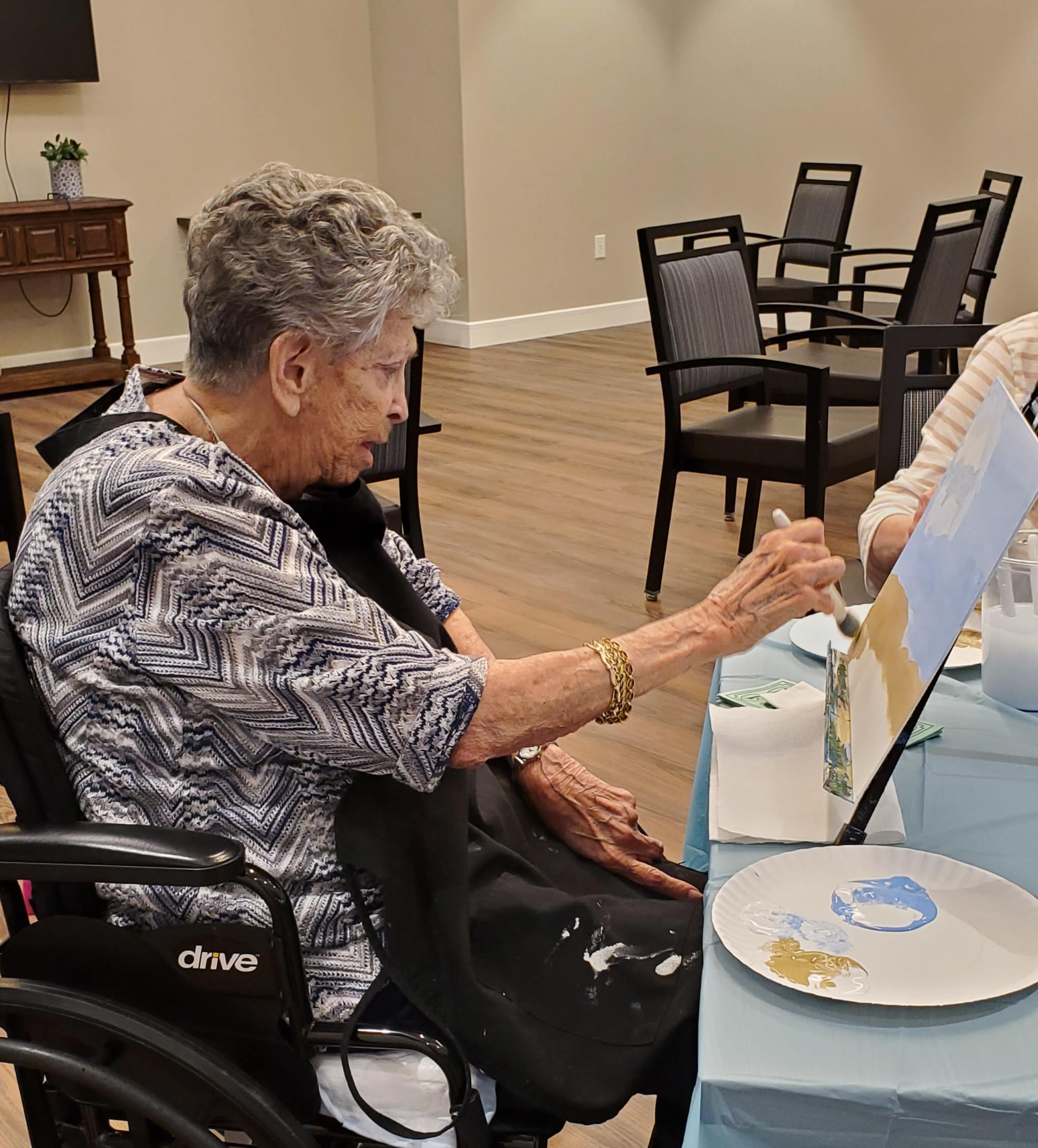 Senior resident enjoying a painting activity.