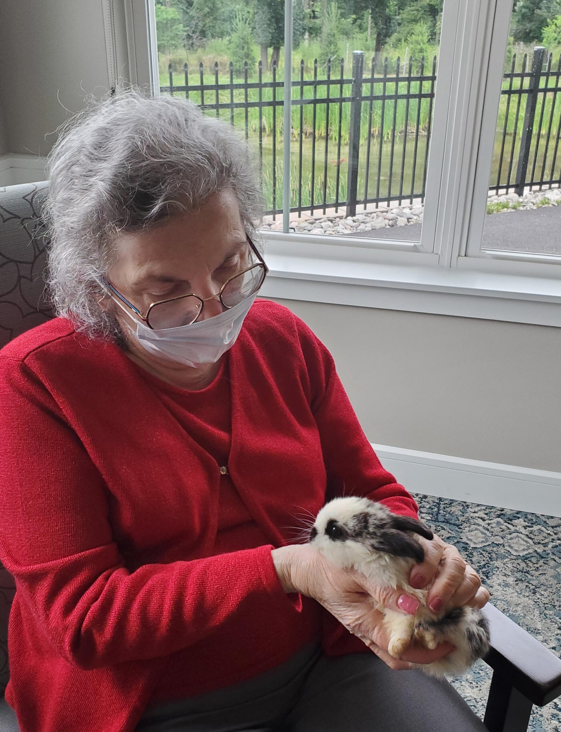 Resident holding a rabbit in a cozy setting.