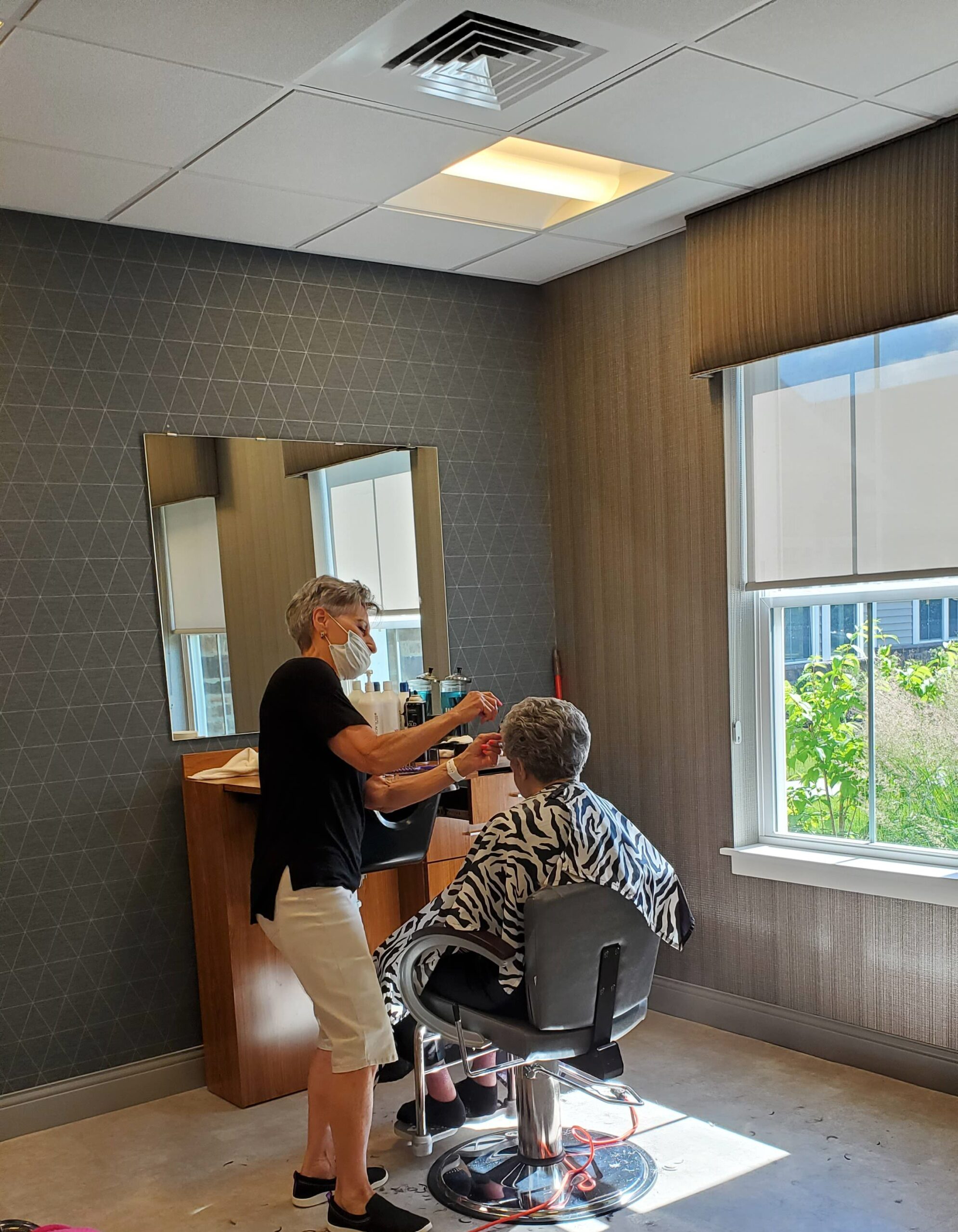Resident receiving hair services in a salon setting.