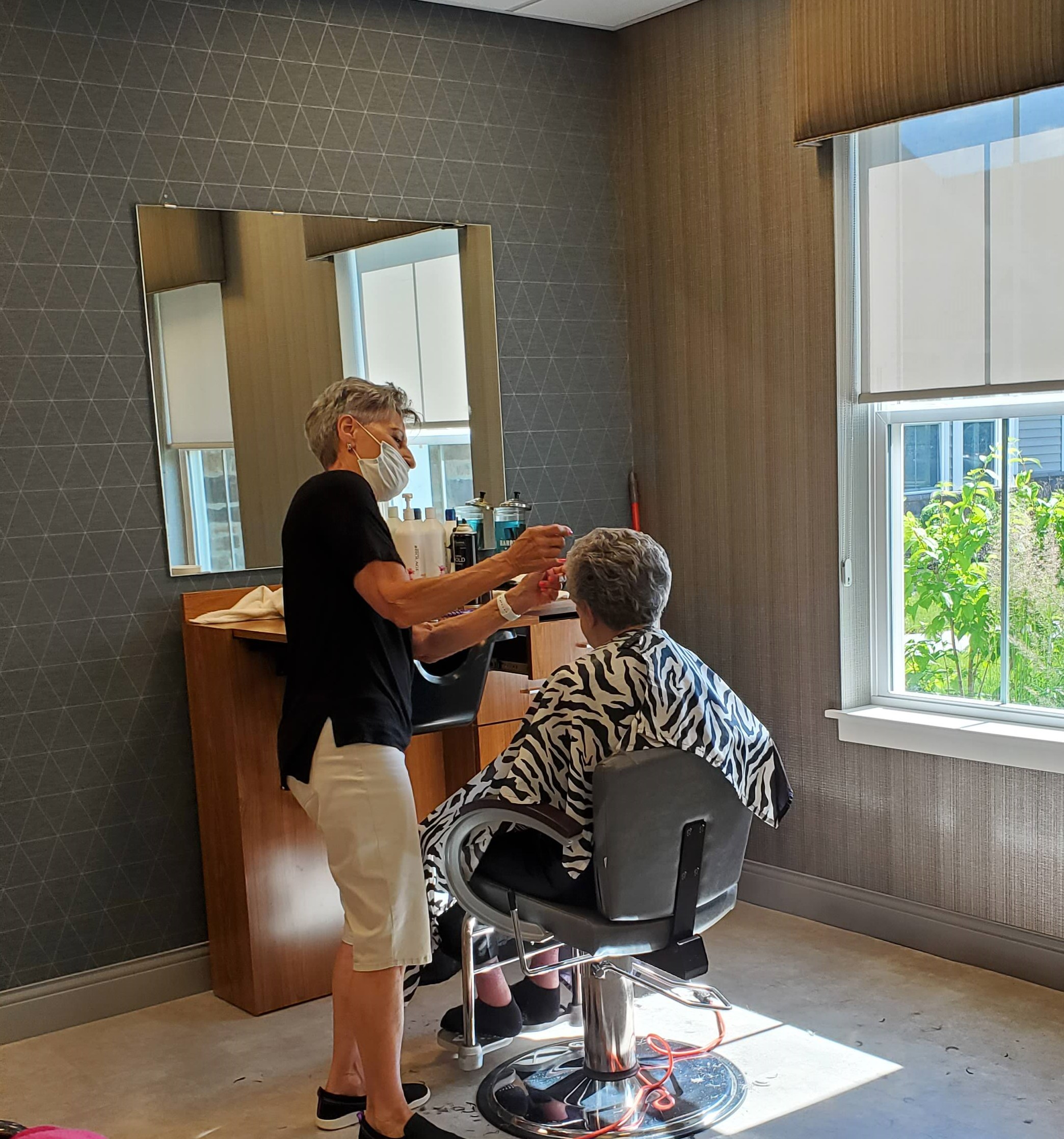Resident receiving a haircut in the salon area