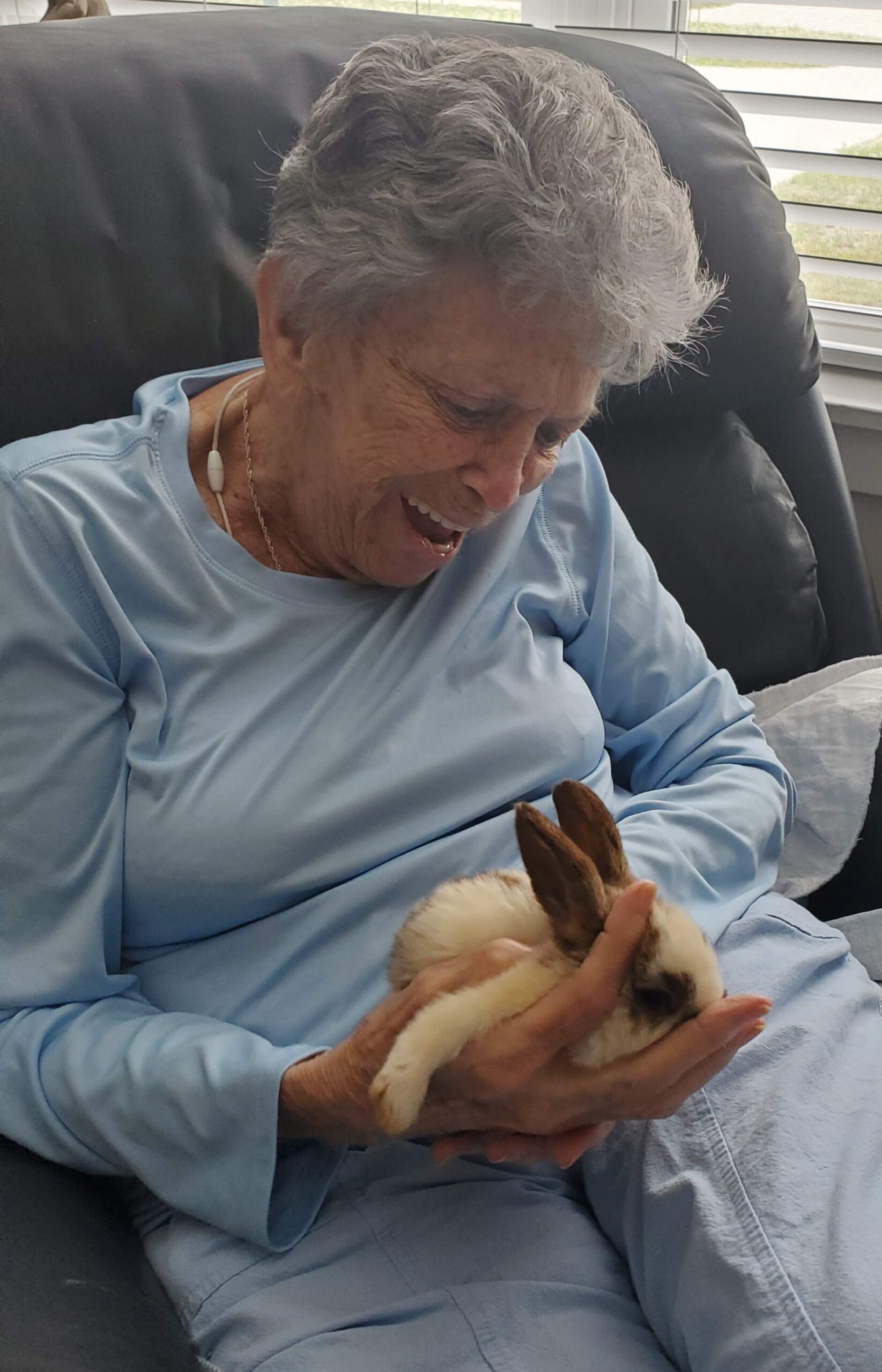 Senior woman joyfully holding a rabbit.
