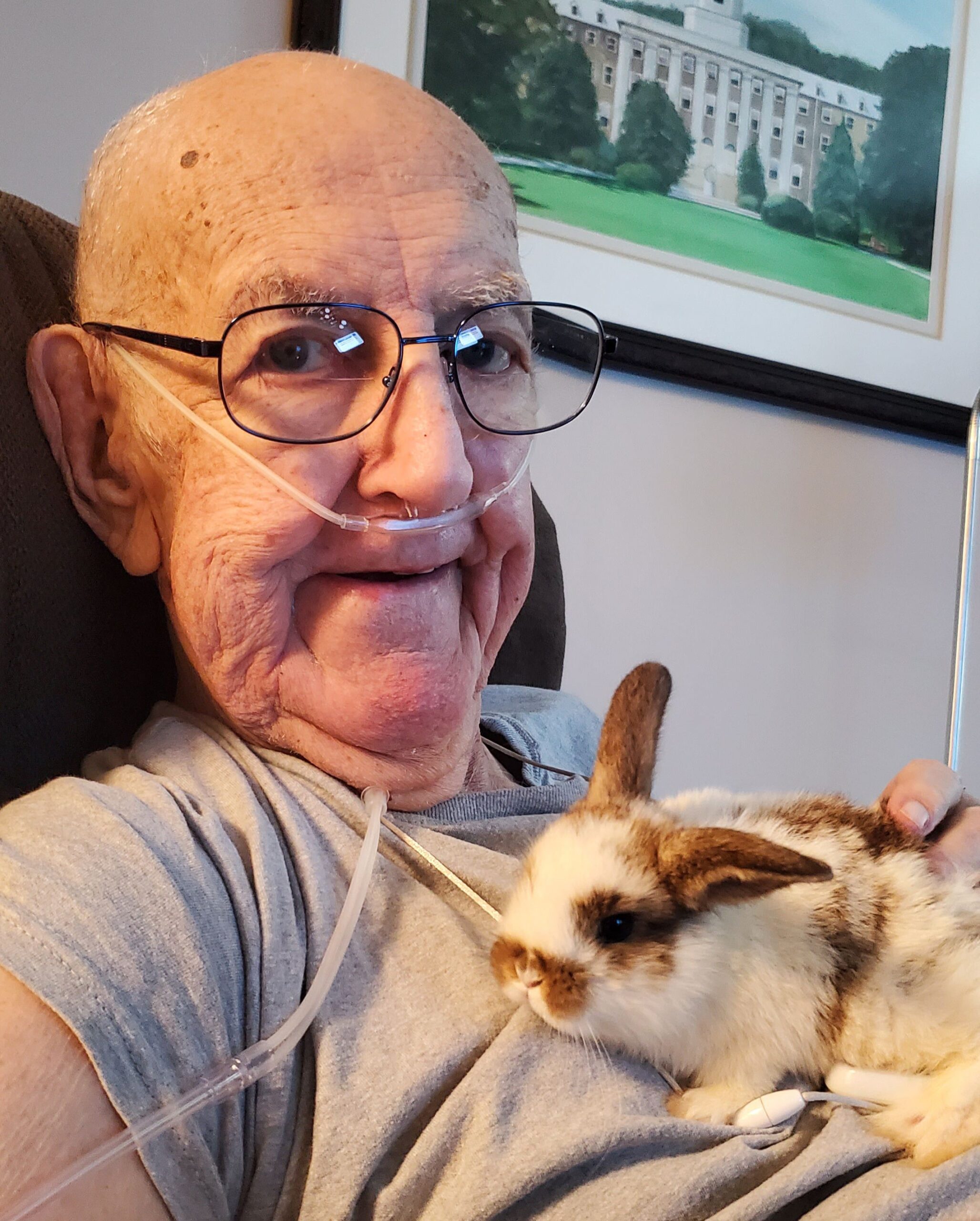 Elderly man holding a rabbit in his lap