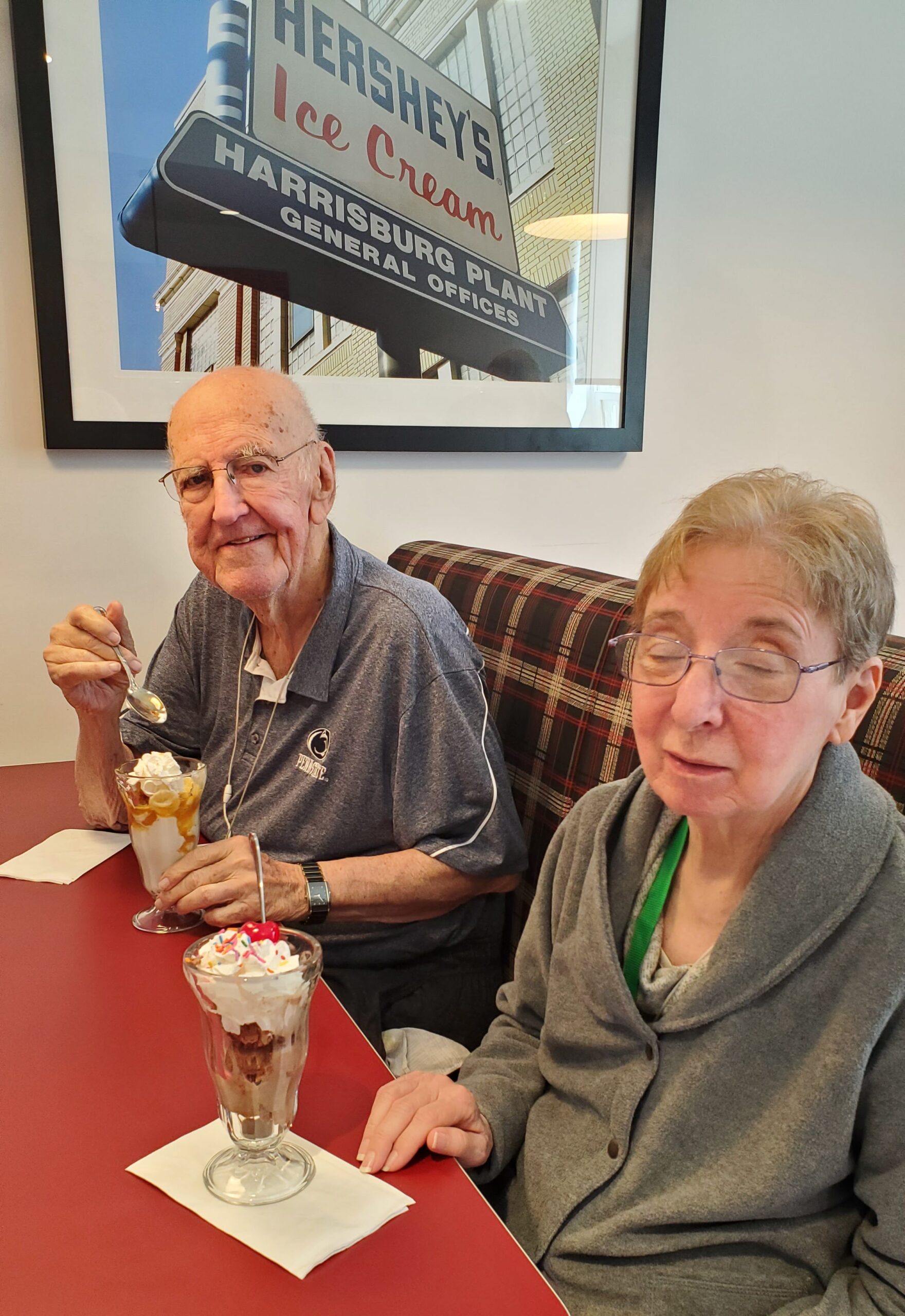 Two residents enjoying ice cream sundaes indoors.