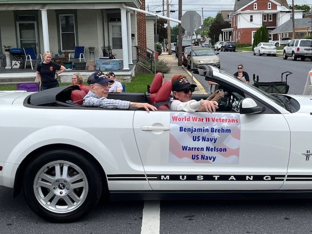 WWII veterans celebrating in a parade convertible