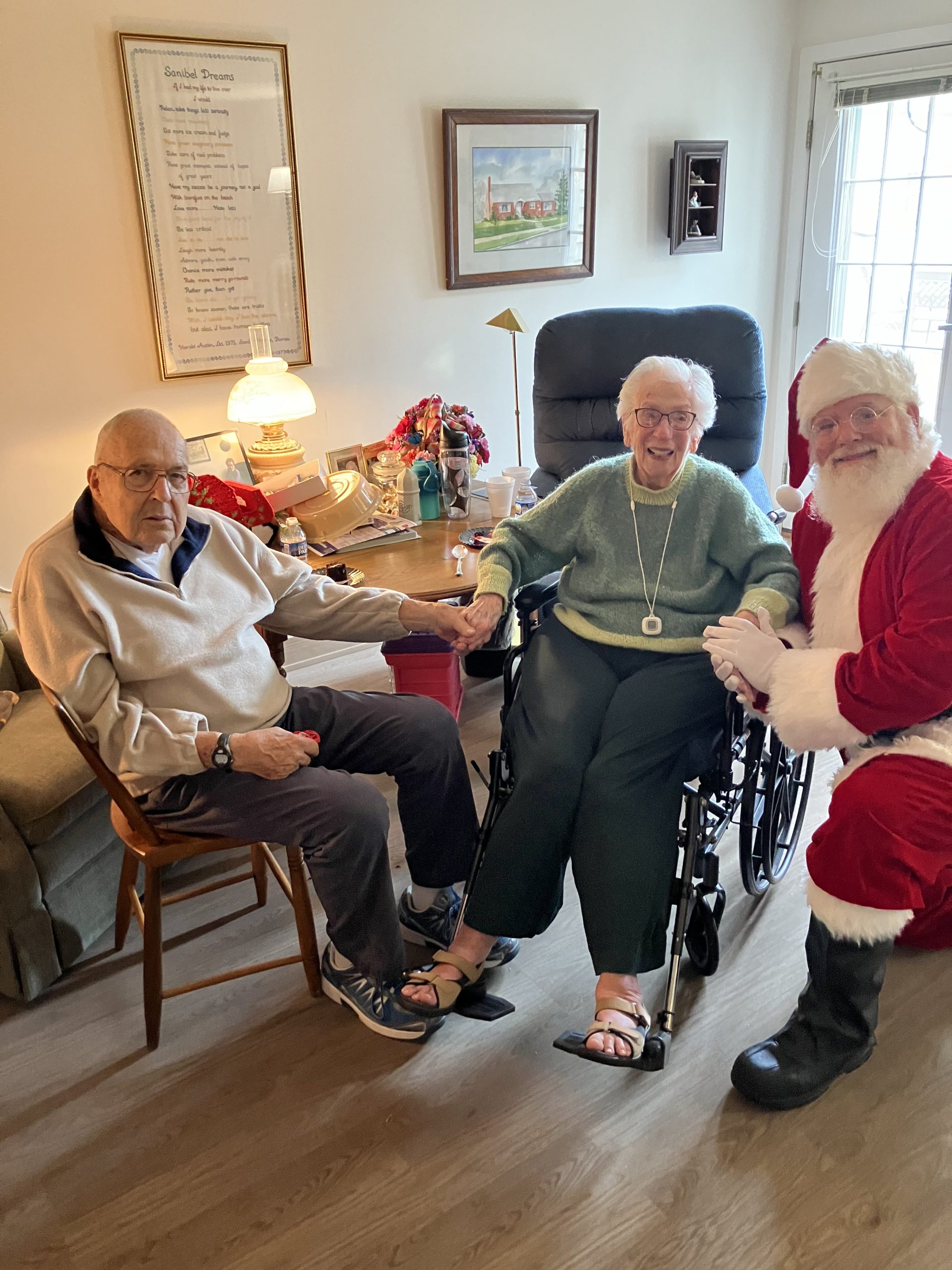 Residents celebrating with Santa Claus in a cozy living room.