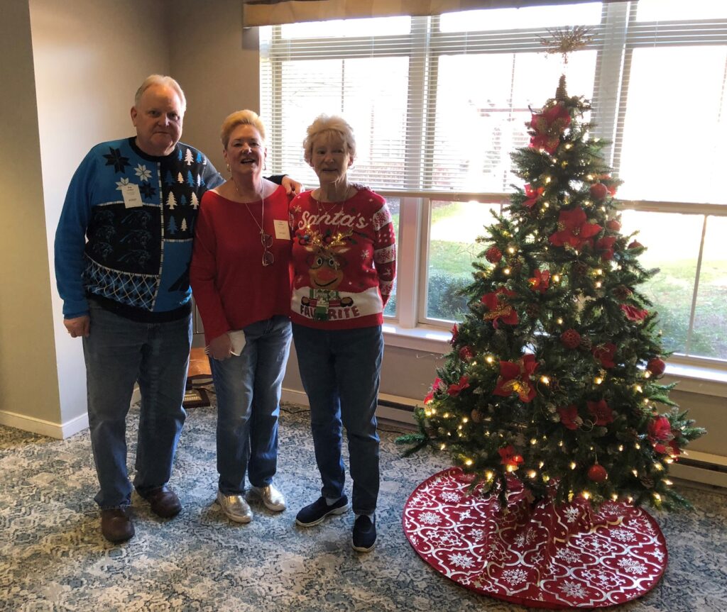 Residents celebrating by a decorated Christmas tree