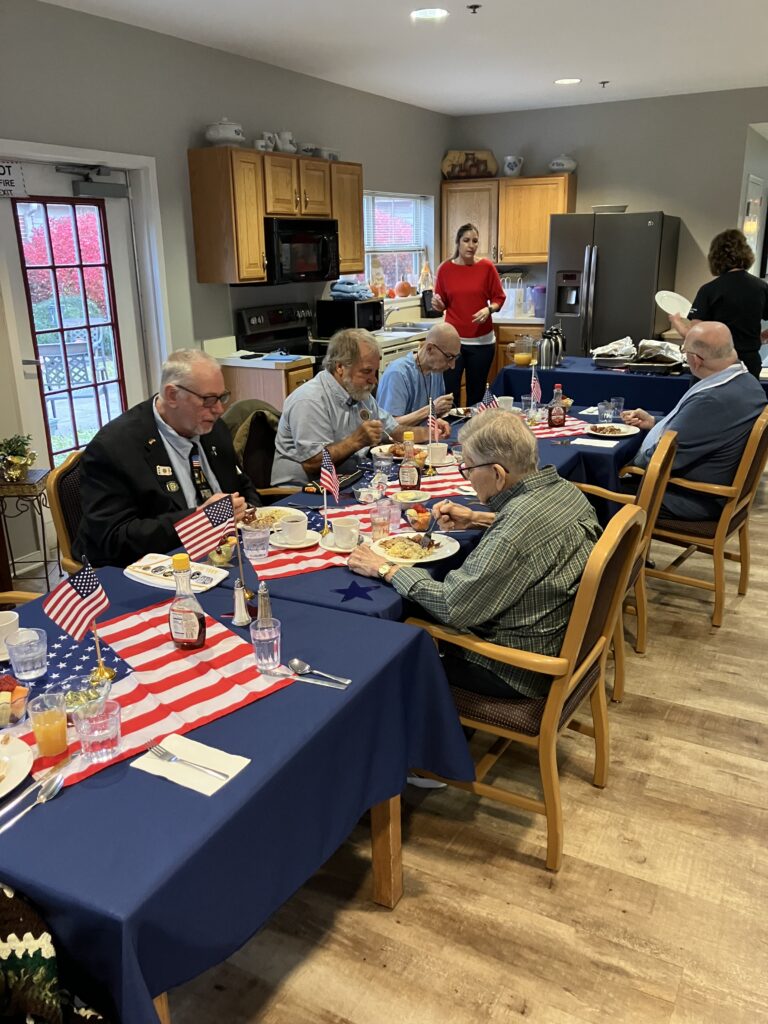 Residents dining with flags at a communal table.