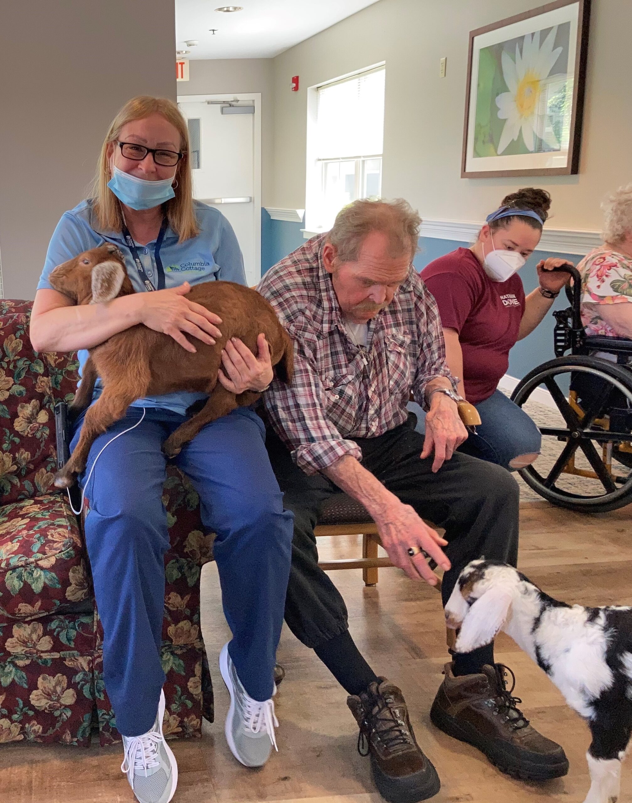 Staff member and residents interacting with pet goats.
