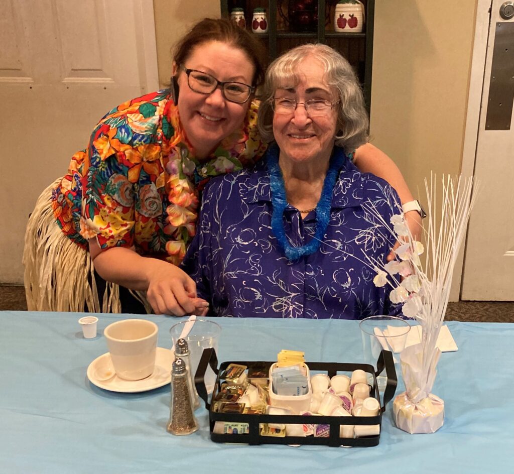 resident with staff member celebrating together