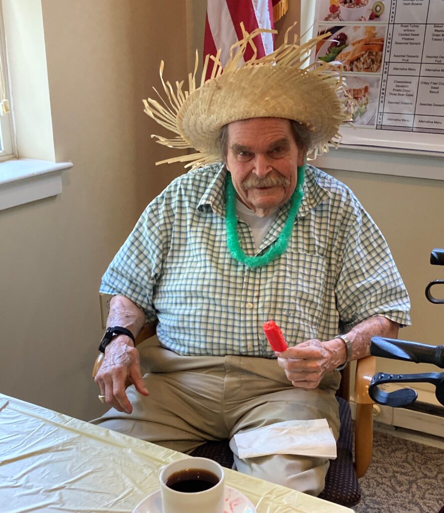 Resident celebrating with straw hat and necklace