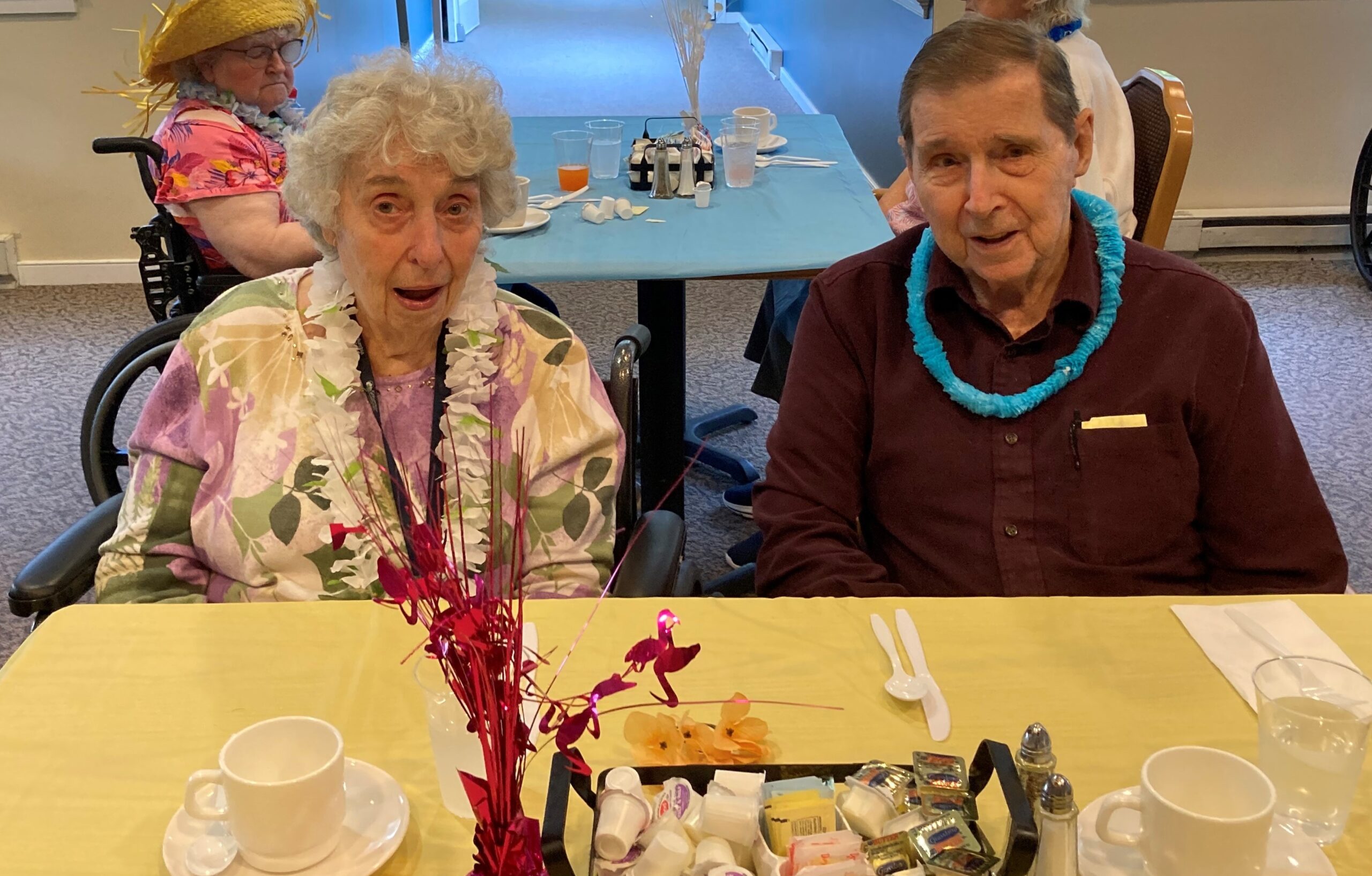 Two residents enjoying a meal together, festive decorations.