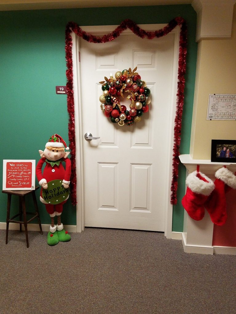 Festively decorated door with stockings and wreath.