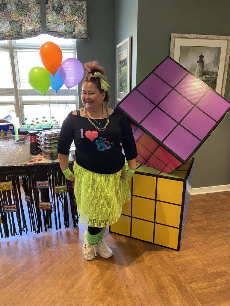 Staff member dressed for a themed celebration indoors.
