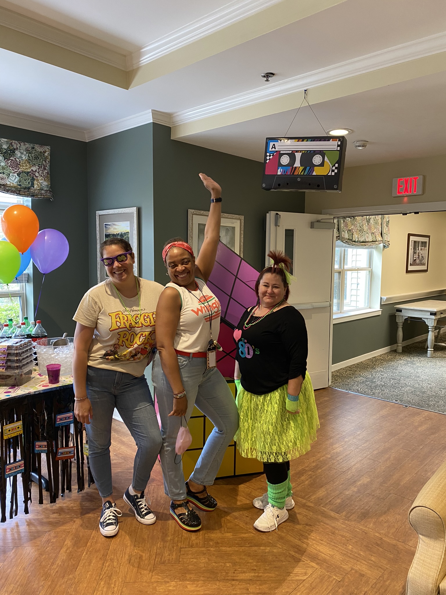 Three staff members celebrating in a common area.