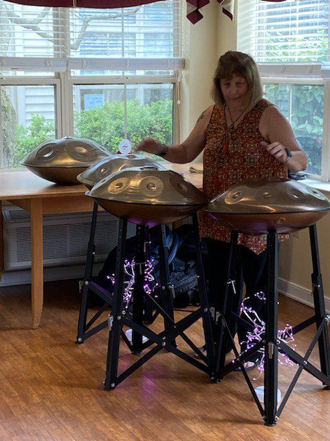 Resident playing handpan instruments in a common area.