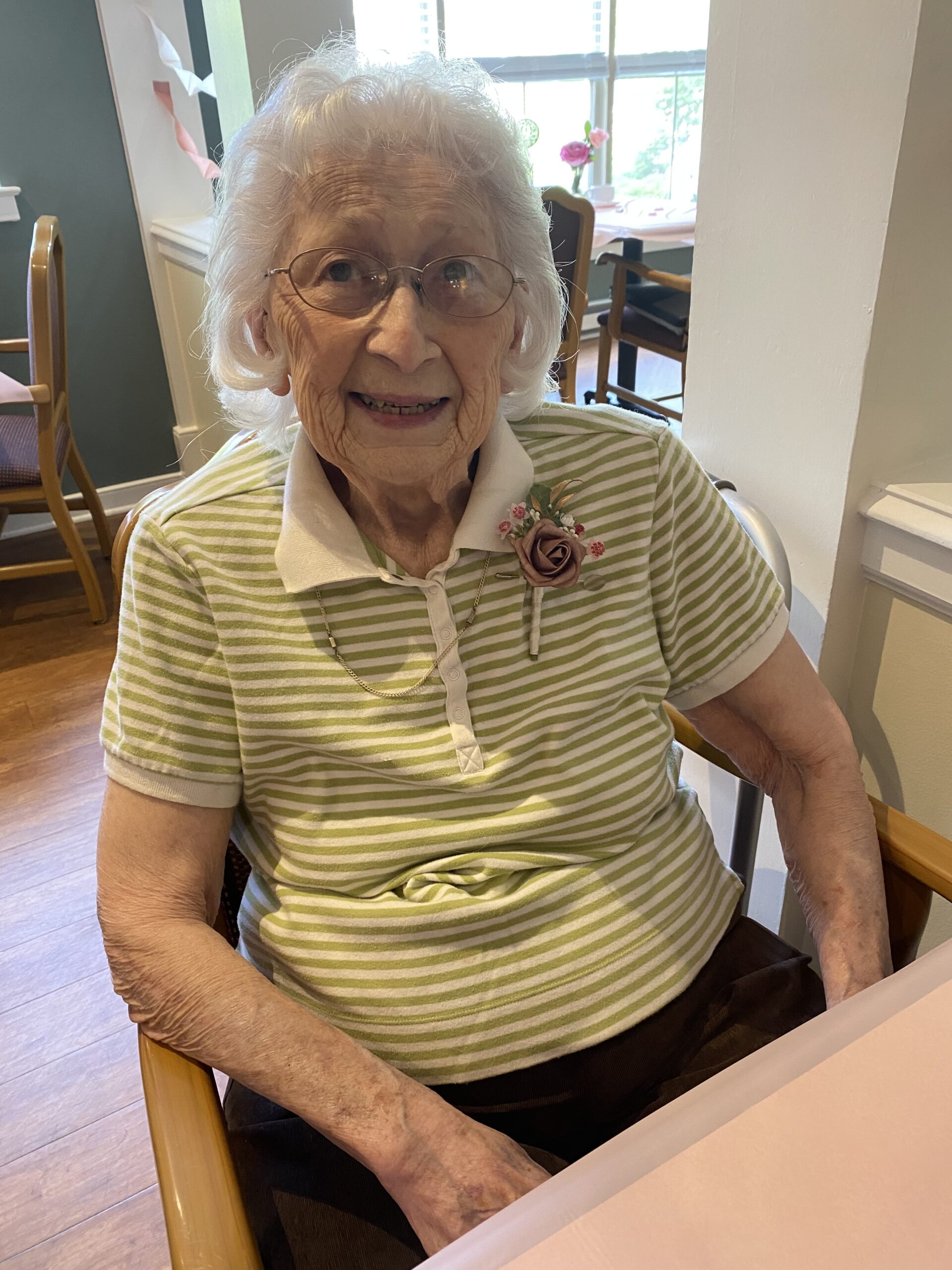 Smiling elderly woman seated in a dining area